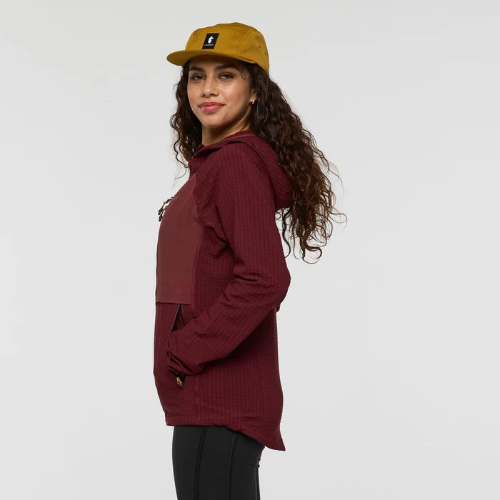Woman wearing a maroon hoodie and yellow cap on a white background