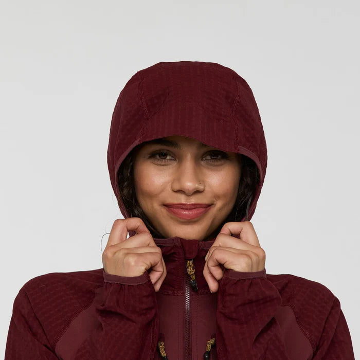 Person wearing a maroon hooded jacket against a plain background