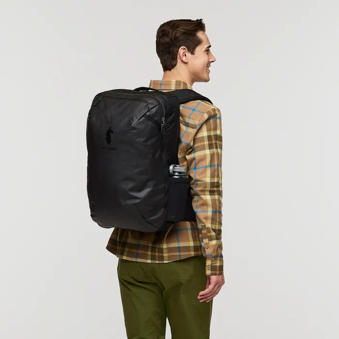 Cotopaxi Allpa 35L Travel Pack Black showing a man wearing it
