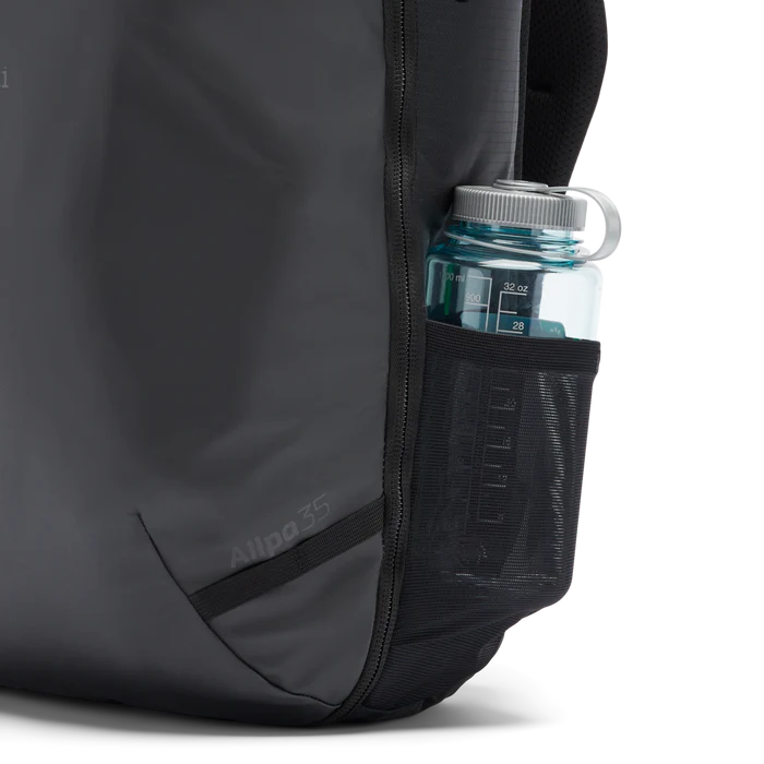 Cotopaxi Allpa 35L Travel Pack Black showing water bottle holder with water bottle in it.