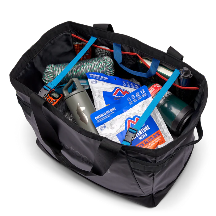 Black duffel bag with various items including a blue strap, water bottle, and packages on a white background.