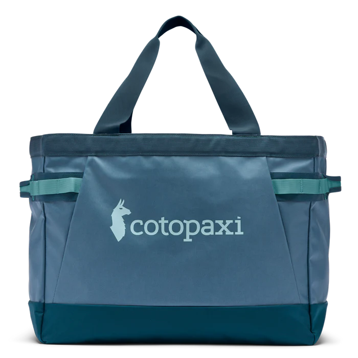 Blue tote bag with Cotopaxi logo on a white background