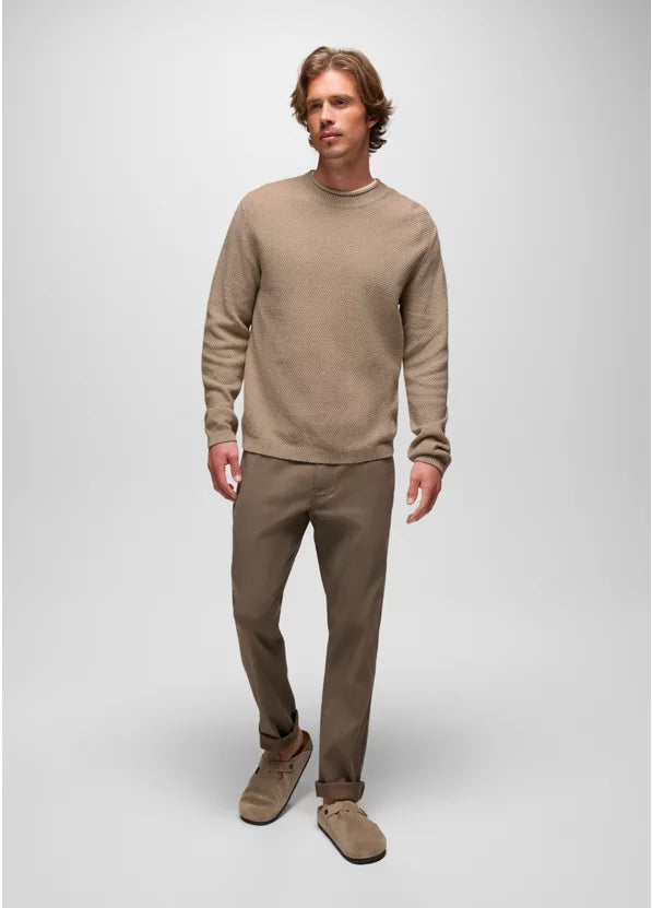 Man wearing a beige sweater and pants on a white background